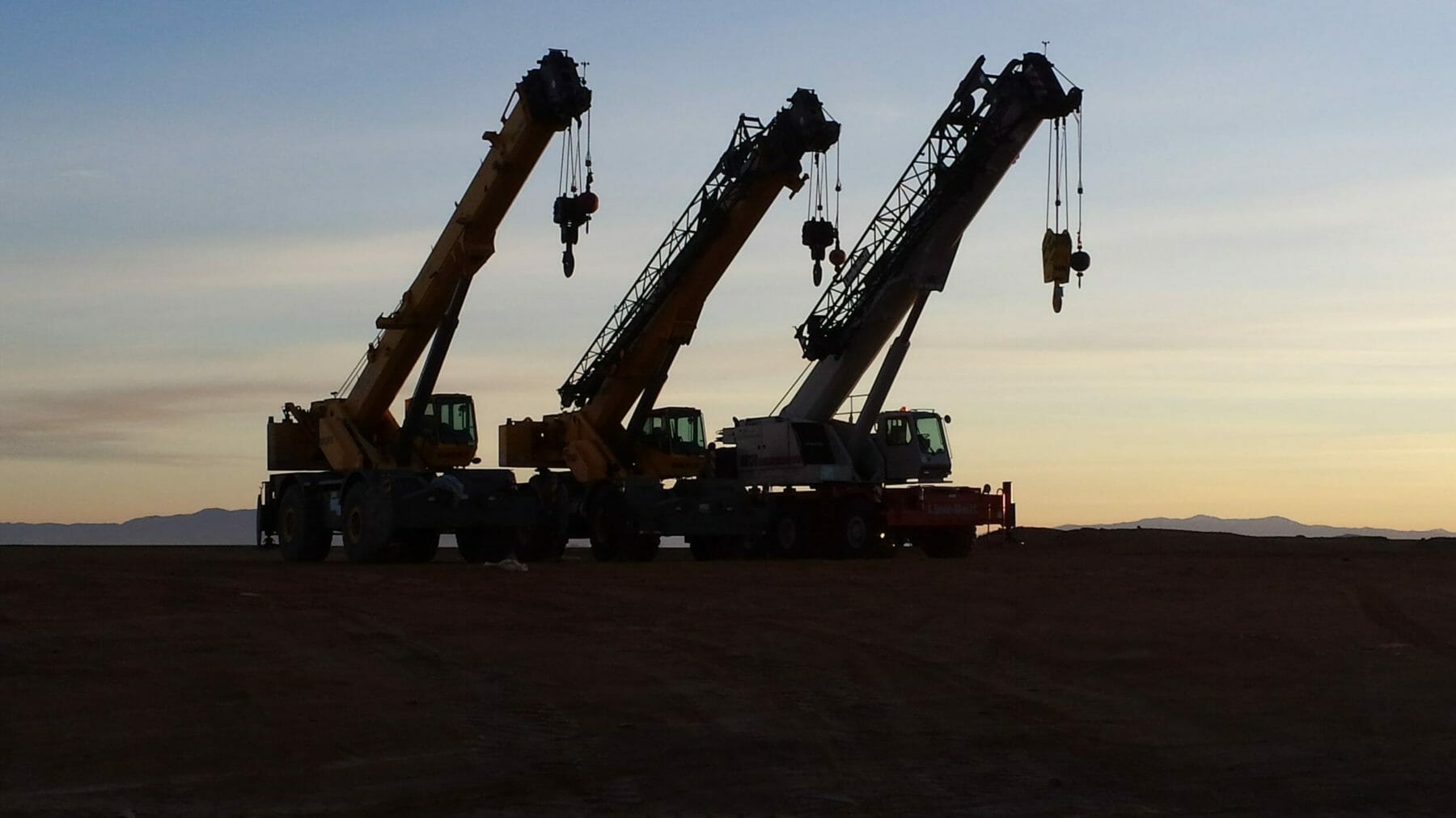 Three Heavy Cranes at Sunset