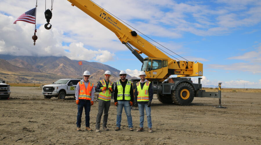 Wollam Construction heavy civil contractors standing in front of crane at industrial construction site in Utah